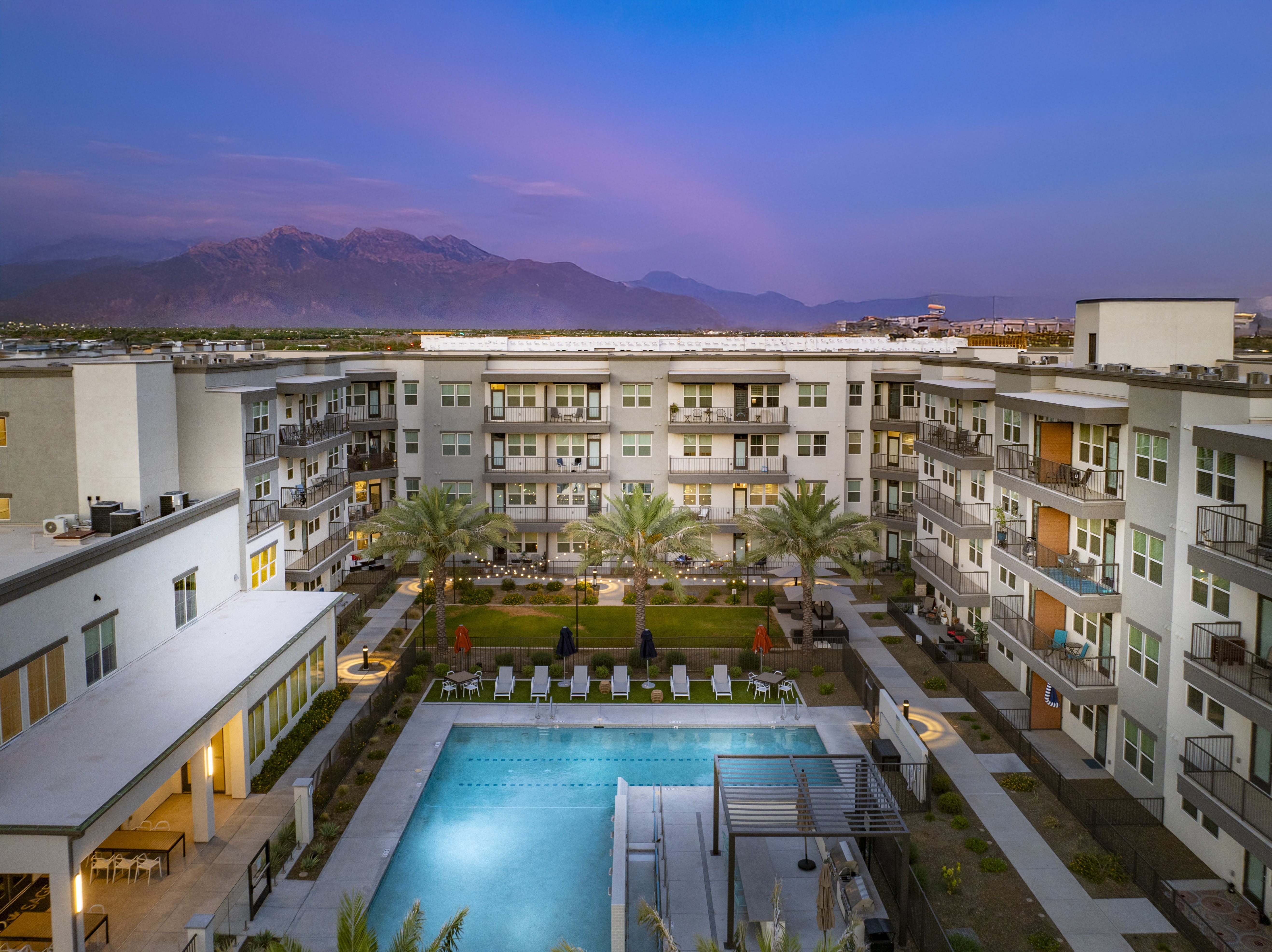 A swimming pool is surrounded by apartment buildings.
